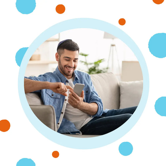 A man smiles at his phone.
