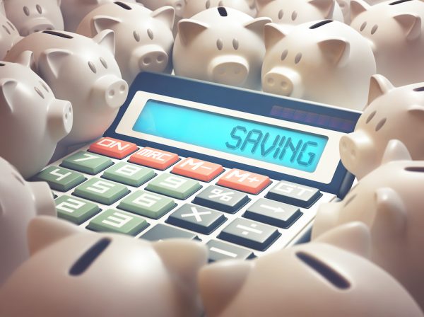 calculator sitting in piggybanks to show money saved with benefits of telehealth