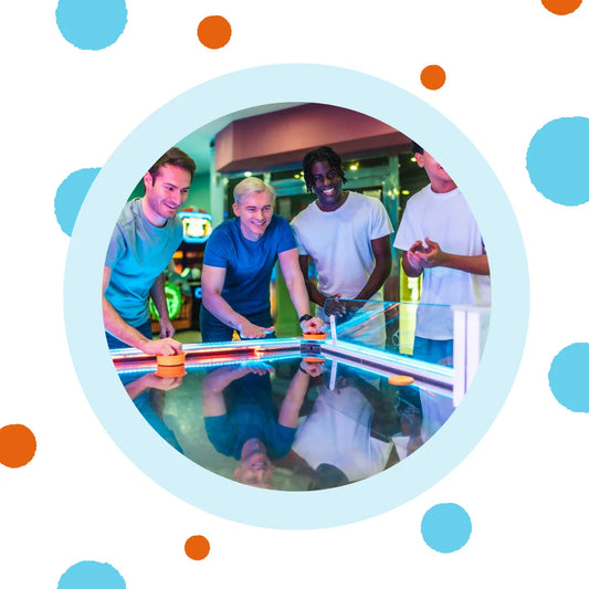 Friends play air hockey together.