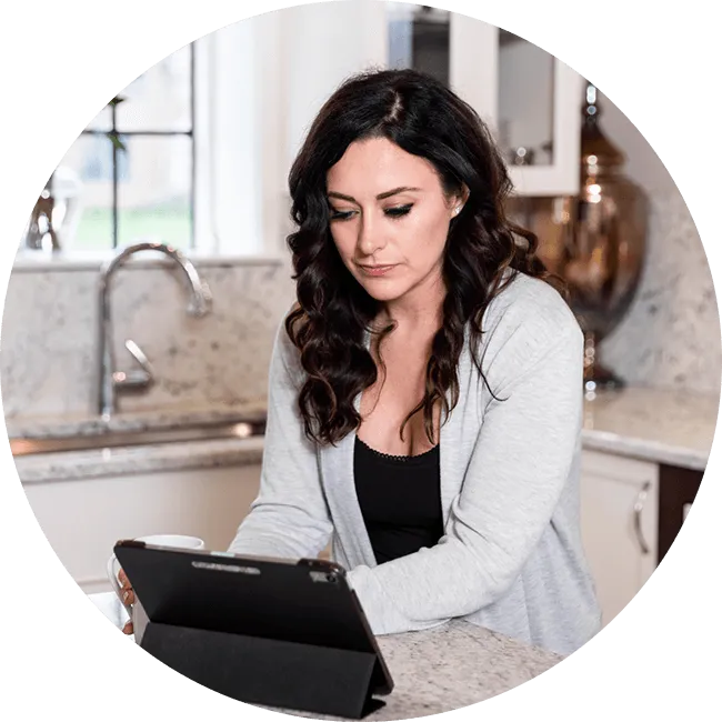 Woman using a tablet in a kitchen setting