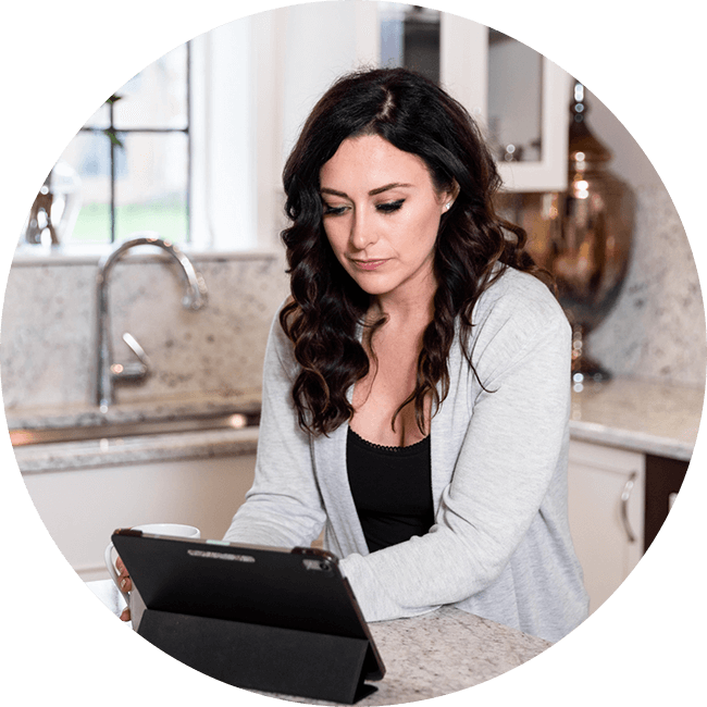 Woman using a tablet in a kitchen setting