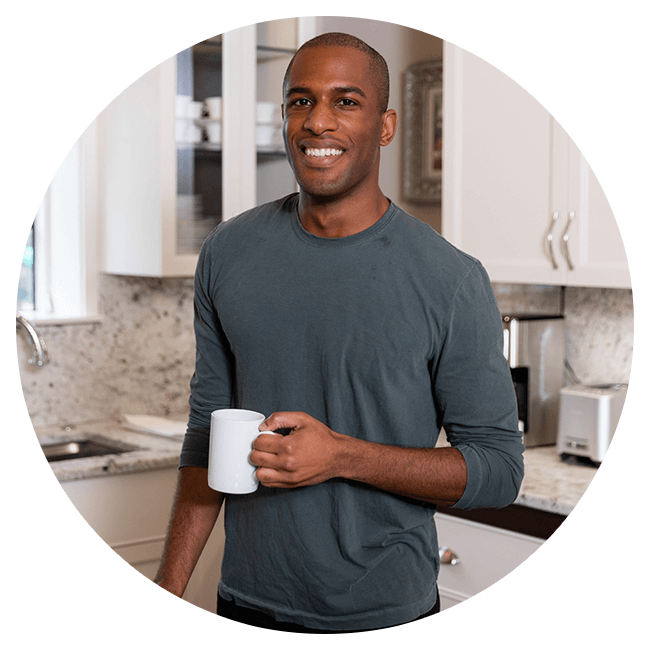 Man holding a white mug in a kitchen