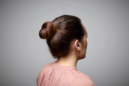 Person with a bun hairstyle on a gray background