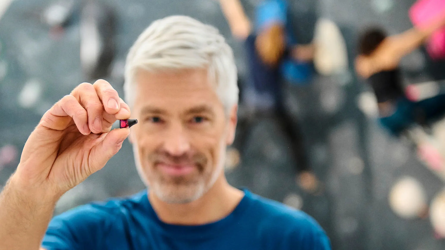Silk-IX man holding hearing aids 