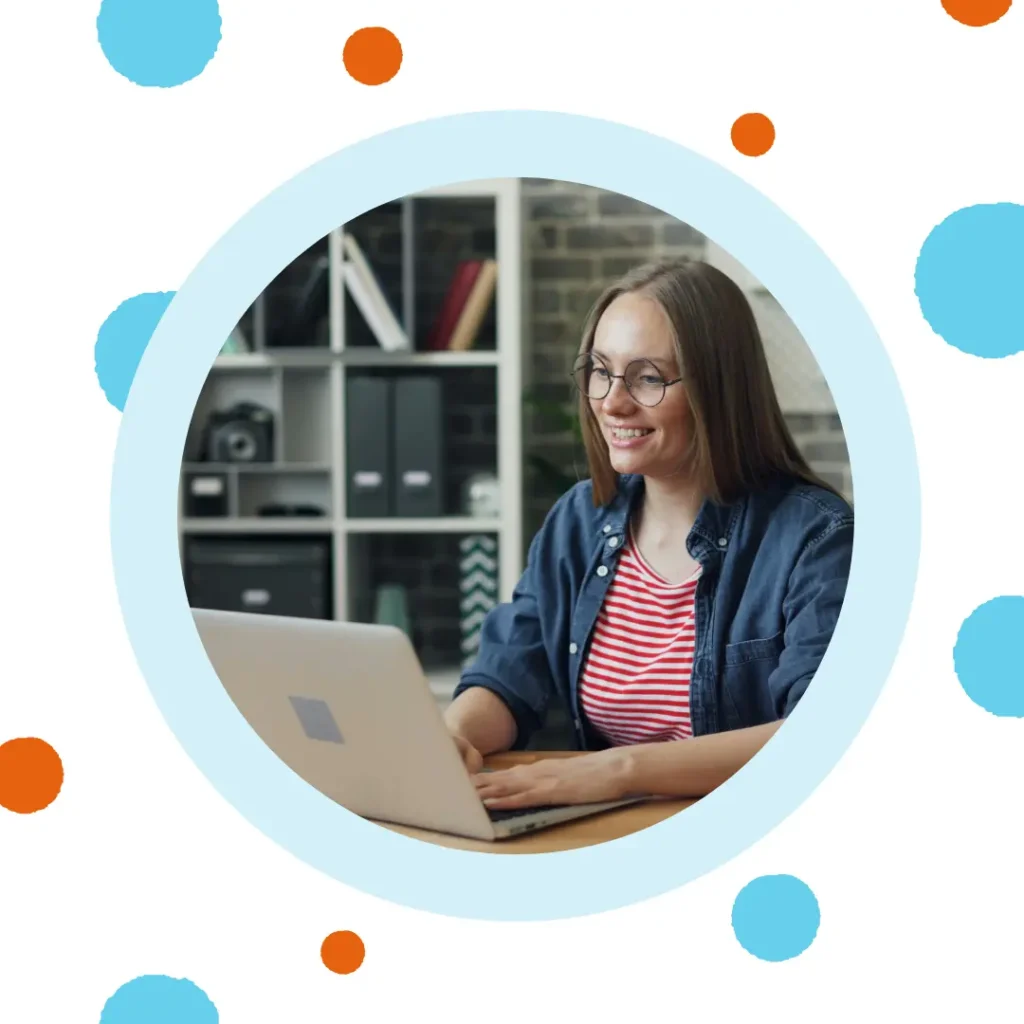 A woman smiles at her laptop.