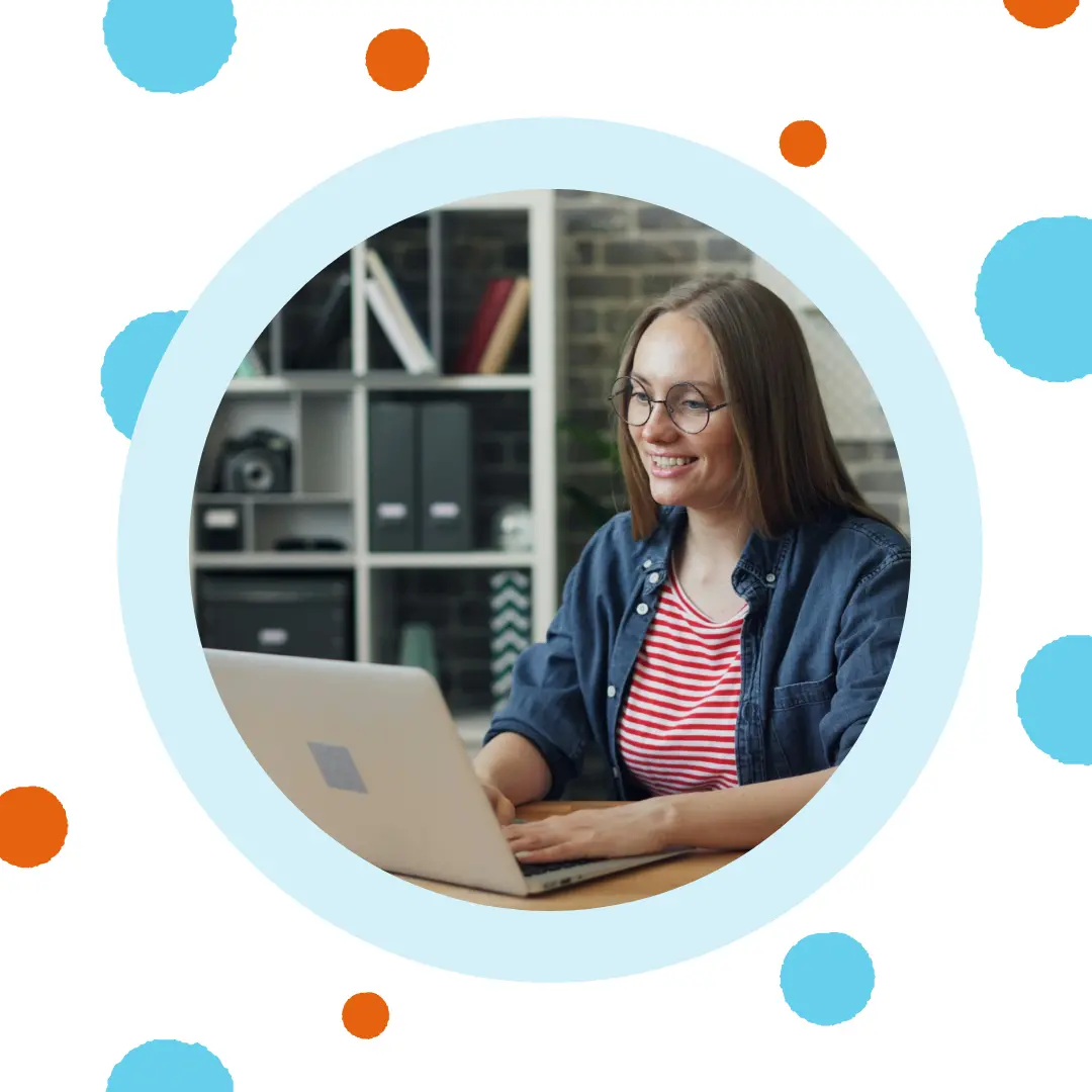 A woman smiles at her laptop.