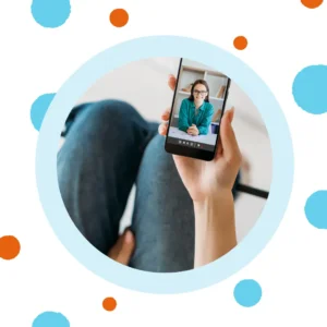 A hand holds a phone with a smiling woman. 