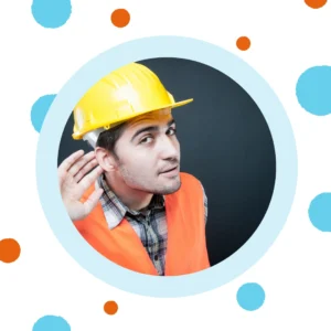 A man in a hard hat cups his ear to hear better. 