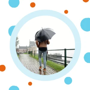 A person walks in the rain with an umbrella.