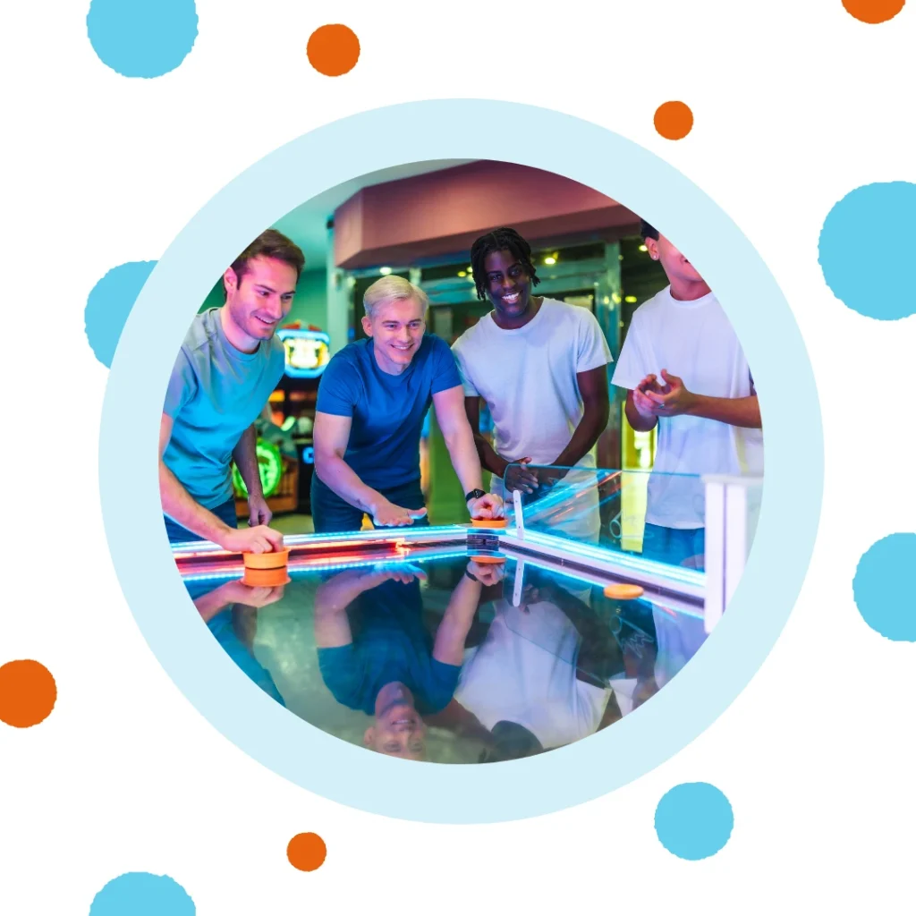 Friends play air hockey together.