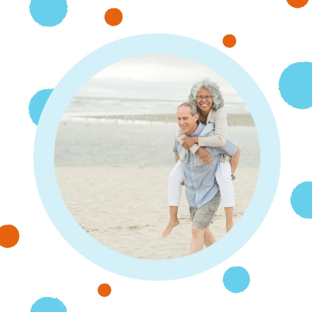 An older couple walks on a beach.