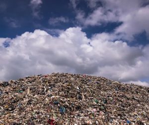 A pile of trash sits under a blue sky