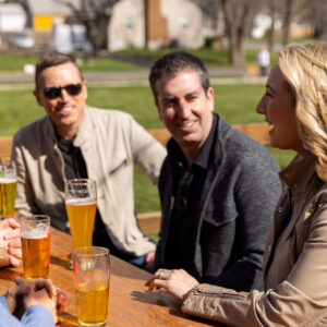 Friends enjoy beers outside.