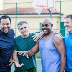 4 older men smile before they play a basketball game.