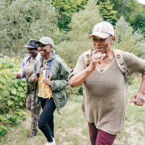 Three older people hike in the wilderness.