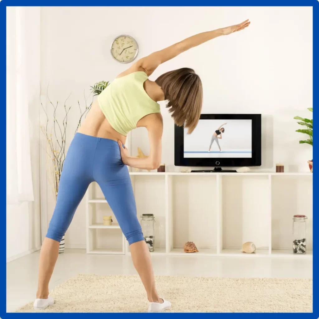 A woman exercises in front of the TV.