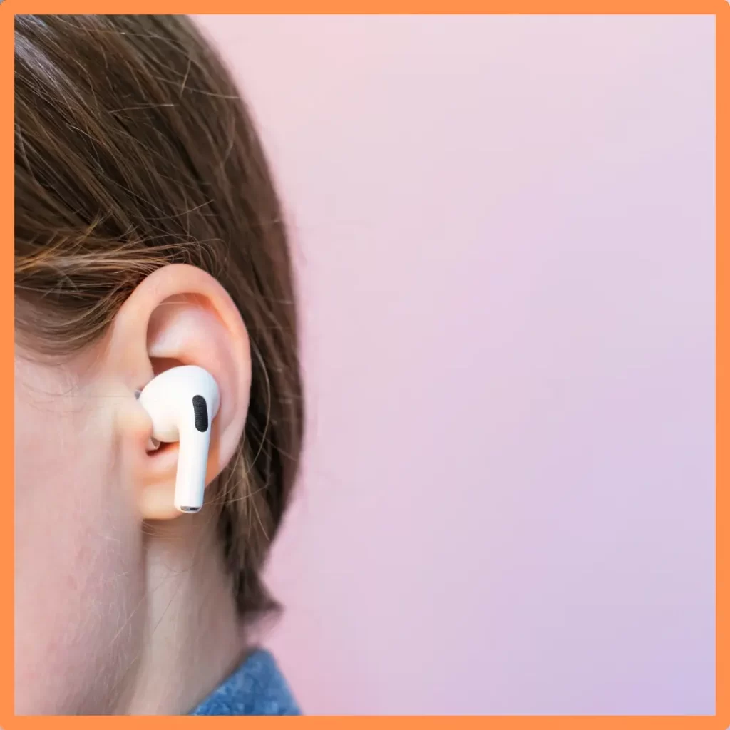 An ear with an AirPod inside of it.