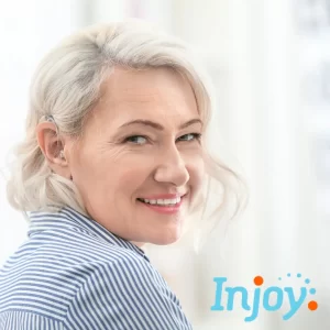 A woman wearing a hearing aid smiles. 