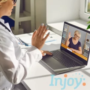 An audiologist waves at a patient online. 