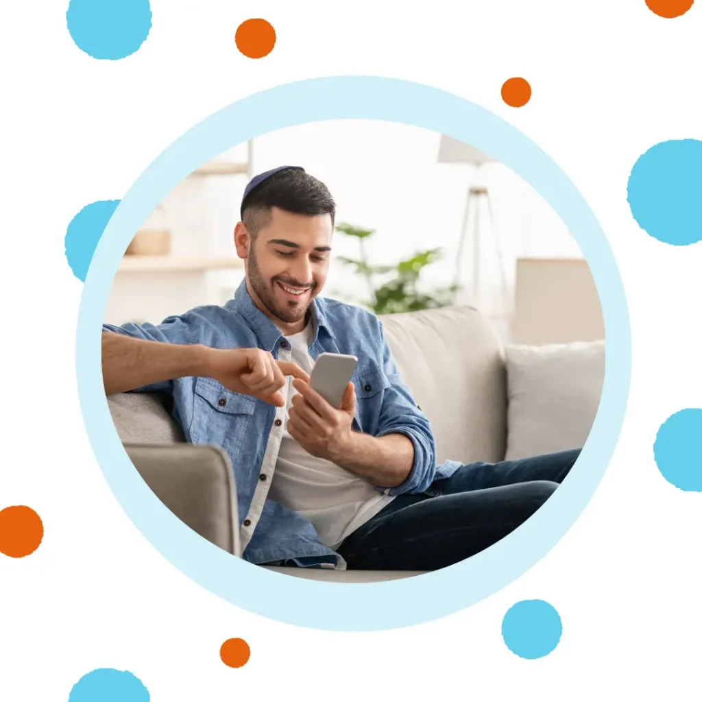 A man smiles at his phone.