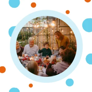 An extended family gathers for a meal outside. 