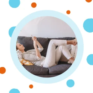A woman relaxes on a couch while online shopping. 