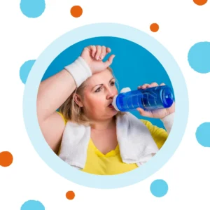 A woman drinks water after exercising.