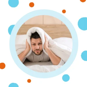 A man holds his ears while being unable to sleep. 