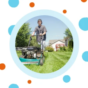 A person wearing ear phones mows a lawn. 
