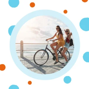 People ride bikes together at the beach. 