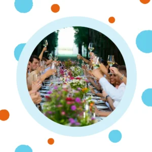 People at a dinner party raise their glasses to toast. 