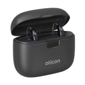 Hearing aids sit in a black charging case. 