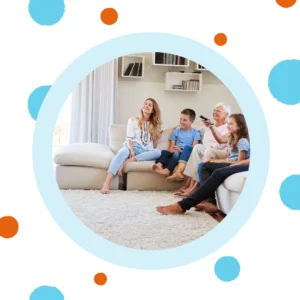 A grandma watches TV with her family.
