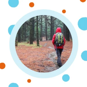 A person hikes in the rainy woods. 