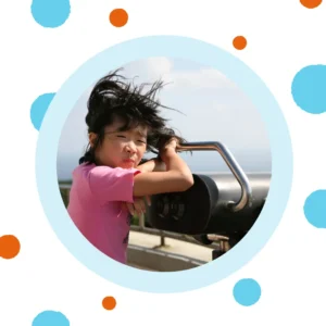 A little girl stands in the wind. 