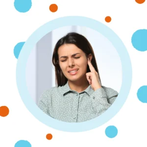 A woman presses on her ear. 