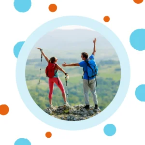 A couple stands on top of a mountain. 