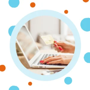 A woman holds a credit card while typing on her laptop. 
