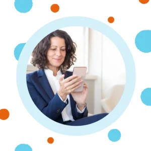 A woman smiles at her phone. 