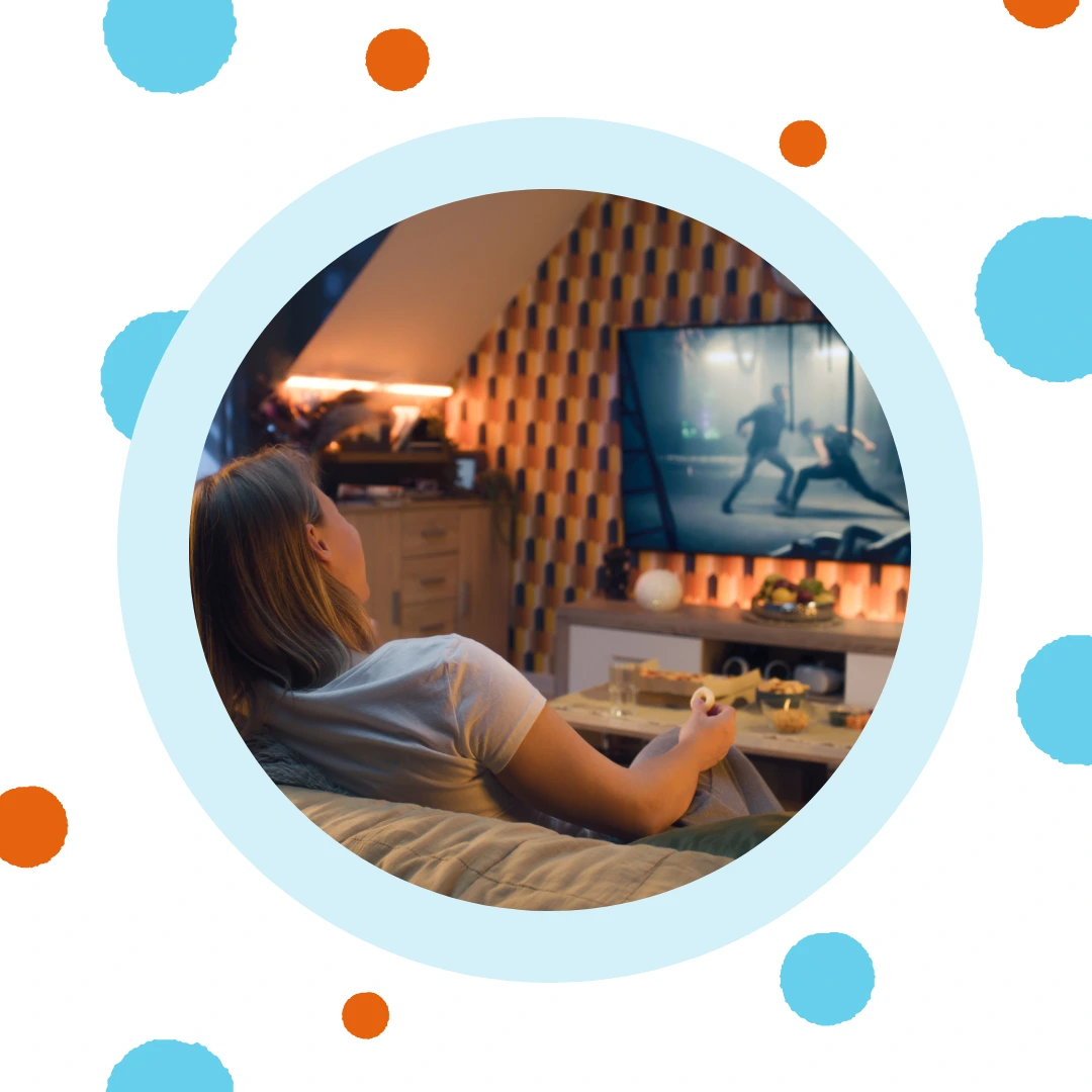 A person watching television on their couch.