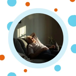 An older man naps on a couch. 