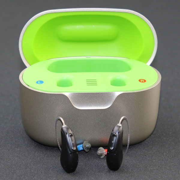 Two Injoy Security hearing aids outside of charging case
