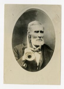 old picture of man using ear horn as example of old style of aid when replacing my hearing aid