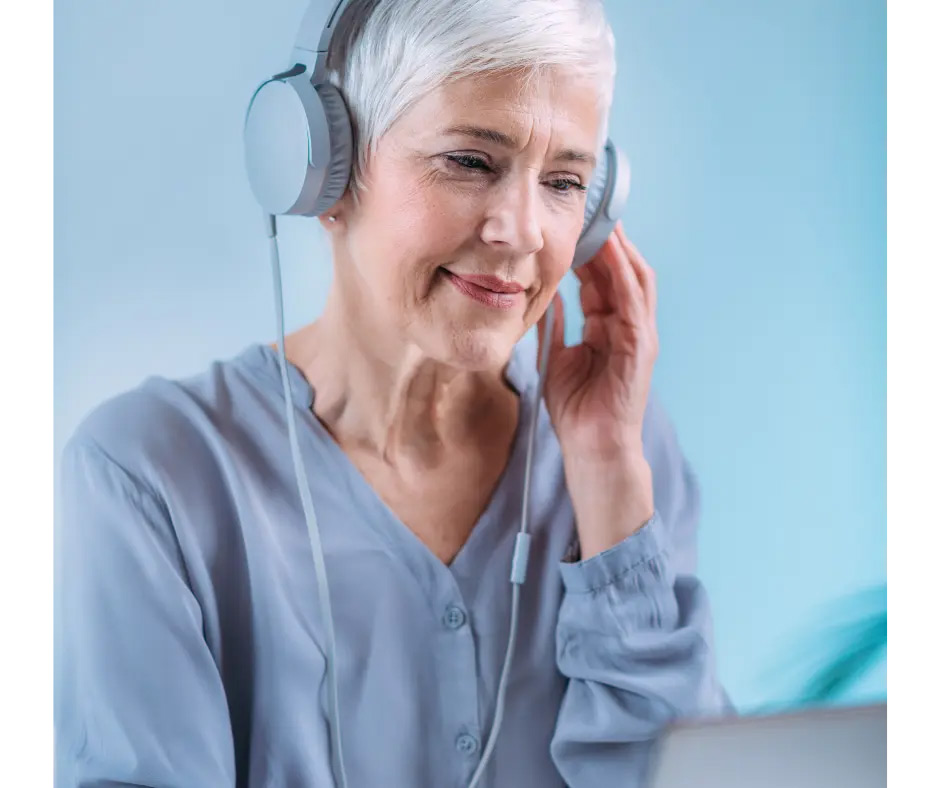 An older woman with headphones takes an online hearing test.