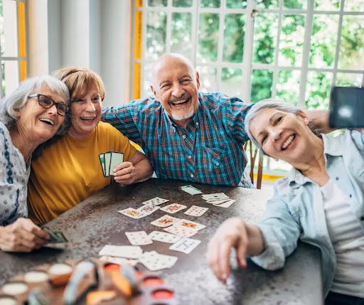A happy group of older adults plays cards